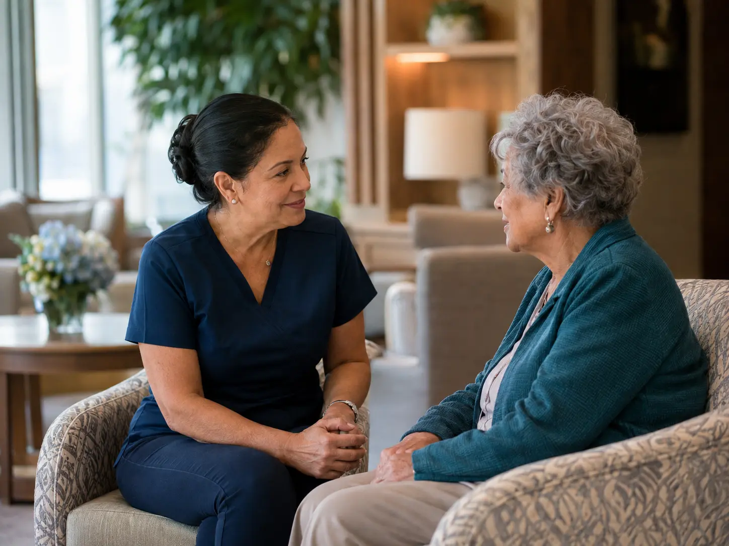 Senior-care staff member listening attentively to an older resident